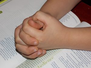 bidden kind handen vouwen bijbel gebed